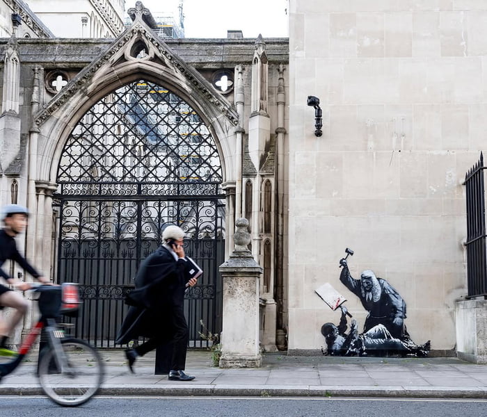 Banksy painted graffiti on the Royal Courts of Justice building in London, depicting a judge beating a protester with a hammer.