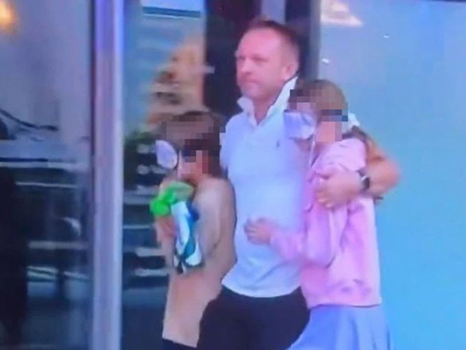 A father leaving the scene of the Bondi Junction Sydney mall with his children, but he covered their eyes with masks, so that they wouldn’t see the horror.