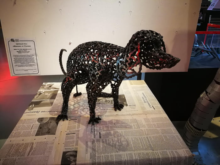 Sculpture of a pooping dog, made out of old bicycle chains