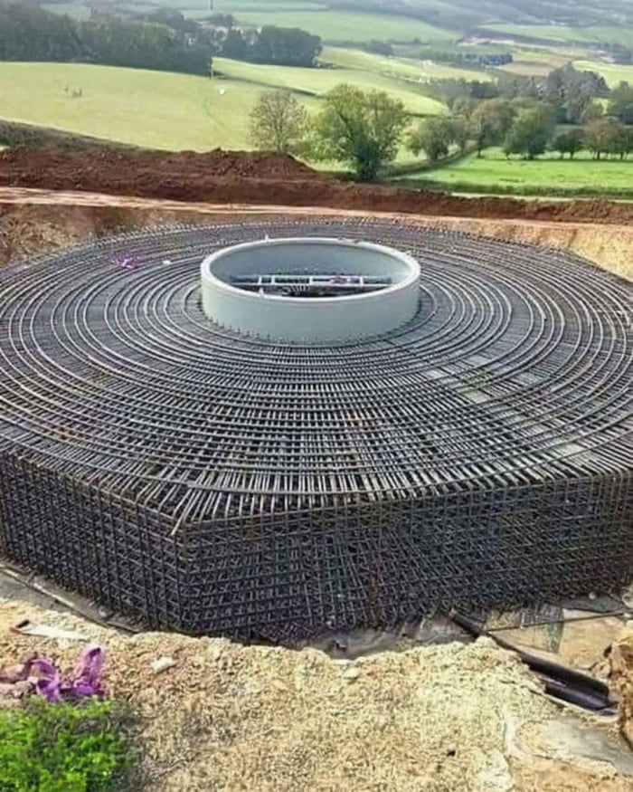 The amount of steel used for the base of a wind turbine ranges from 120-180 tons. This then gets buried in 300-900 yards of concrete depending on the windmill size.