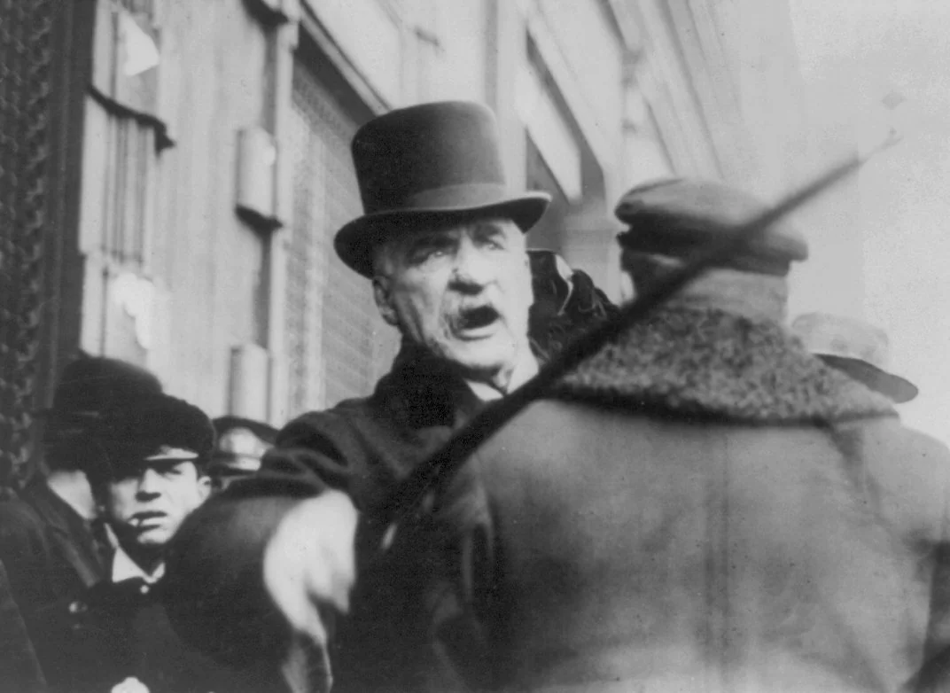 JP Morgan seen trying to attack a man for pulling a drowning puppy from the water, 1910
