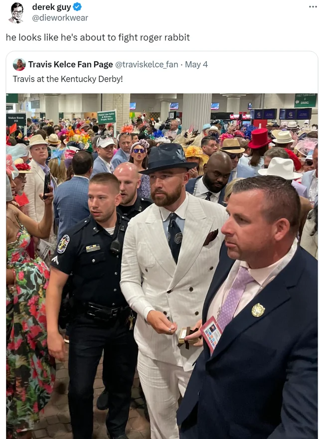 what's more confusing, his outfit or the fact that he's being escorted by a police officer